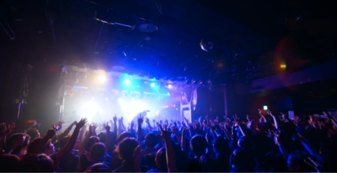 ライブ会場で観客が手を挙げて盛り上がる様子